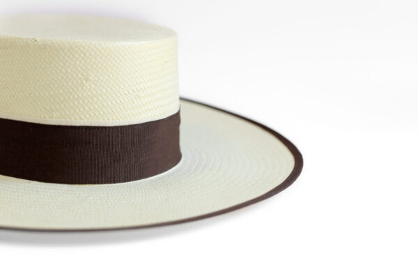 Detalle de sombrero blanco con cinta marrón.