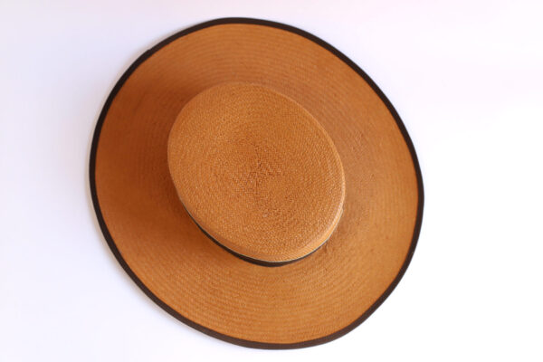 Sombrero marrón visto desde arriba con borde negro.