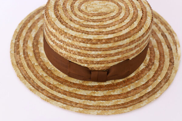 Sombrero de rafia a rayas beige y marrón con cinta decorativa.