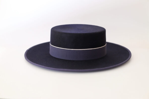 Sombrero azul marino con ala amplia y cinta decorativa a juego.
