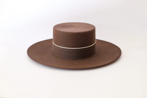 Sombrero marrón de lana con ala ancha y cinta decorativa.